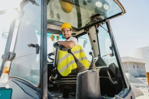 Baumaschinenführer sitzt in einem Bagger und ist startklar für seine Arbeit.
