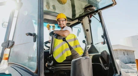 Baumaschinenführer sitzt in einem Bagger und ist startklar für seine Arbeit.