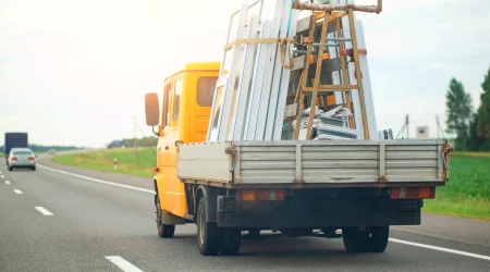 Kleiner Lastwagen mit Ladefläche, transportiert Fenster.