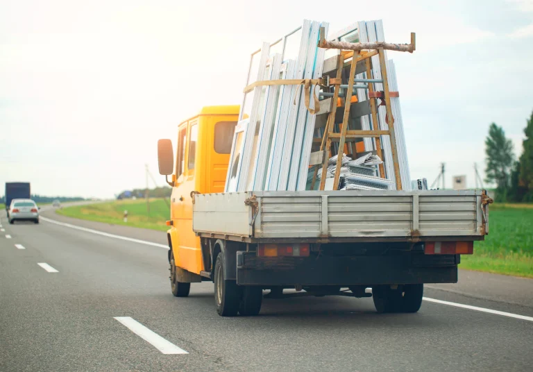 Kleiner Lastwagen mit Ladefläche, transportiert Fenster.