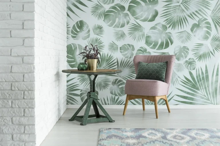 Tropische Mustertapete mit grünen Palm- und Monstera-Blättern als Blickfang in modernem Wohnzimmer mit rosa Sessel und weißer Ziegelwand.