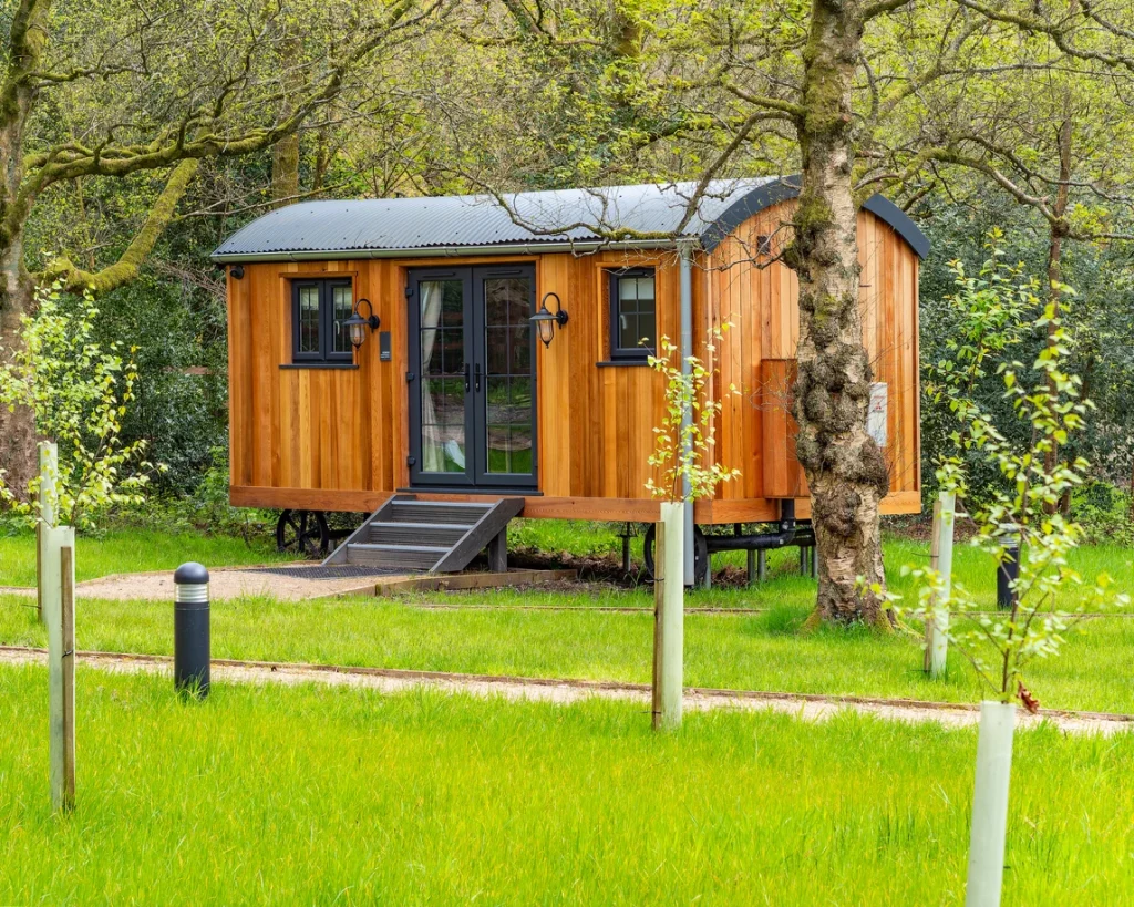 Tiny Haus aus Holz auf dem Land zwischen Bäumen