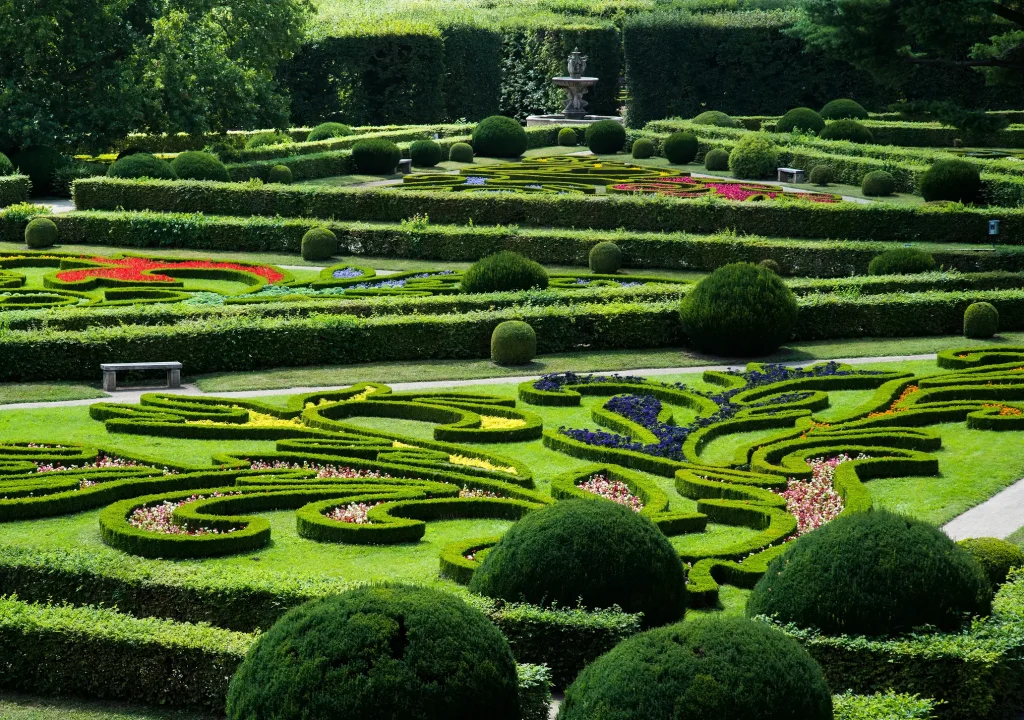 Historischer Blumengarten in Kroměříž mit kunstvoll geschnittenen Hecken, Blumenornamenten und symmetrischen Gartenanlagen in barockem Stil.