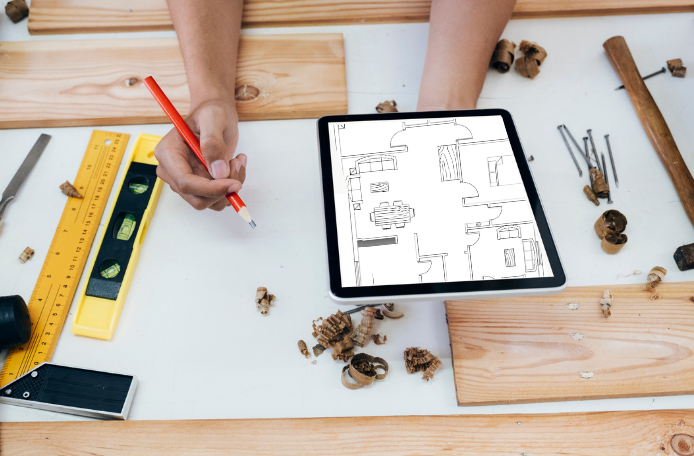 Heizungsmonteur hält einen Grundriss digital auf einem Tablet in der Hand.