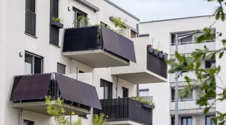 Balkonkraftwerk mit Solarpaneelen an einem Mehrfamilienhaus zur nachhaltigen Stromerzeugung für urbane Haushalte.