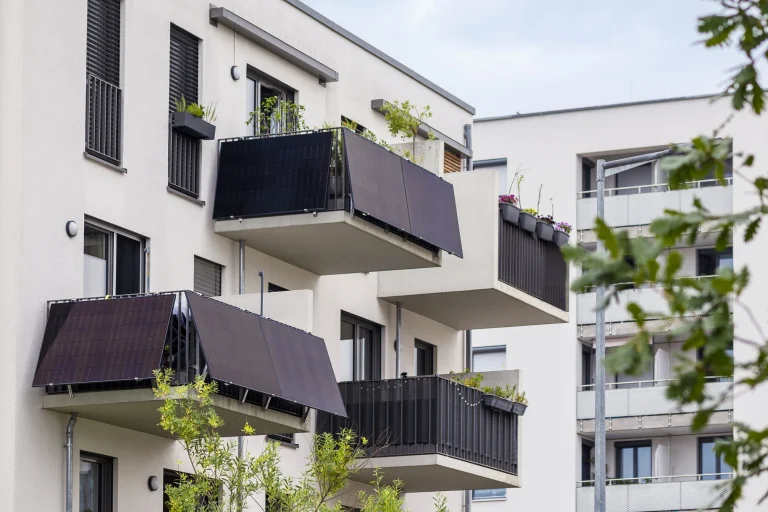 Balkonkraftwerk mit Solarpaneelen an einem Mehrfamilienhaus zur nachhaltigen Stromerzeugung für urbane Haushalte.