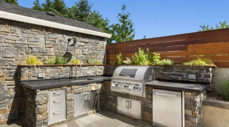 Moderne Hardscape-Terrasse mit Outdoor-Küche und Grill im gepflegten Hinterhof