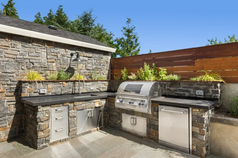 Moderne Hardscape-Terrasse mit Outdoor-Küche und Grill im gepflegten Hinterhof