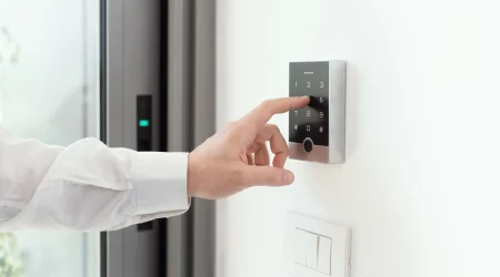Eine Person eines Unternehmens, tippt einen Zugangscode in eine Sicherheitssystem zum Bürogebäude ein.