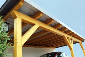 Holz-Carport mit einfachem Flachdach, das mit Dachpappe abgedichtet ist.