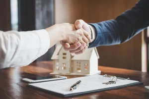Zwei Menschen schütteln sich die Hände nach dem Abschluss eines Finanzplans für den Bau eines Hauses.