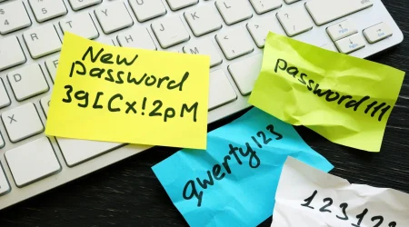 Zerknüllte Post It's liegen verstreut über eine Computertastatur, darauf sind Passwörter zu erkennen.