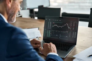 Ein Trader sitzt vor seinem Laptop und kümmert sich um die Steuern.