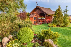 Eine Blockbohlen Gartenhaus in einem Garten.