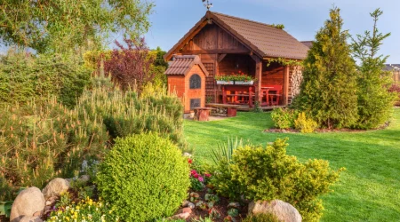 Eine Blockbohlen Gartenhaus in einem Garten.