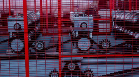 Eine Maschine eingesäumt von einer roten Gittereinhausung.