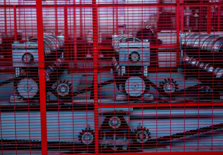 Eine Maschine eingesäumt von einer roten Gittereinhausung.