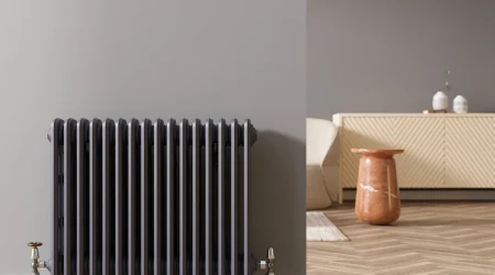 Ein Grauer Heizkörper vor einer grauen Wohnzimmerwand.