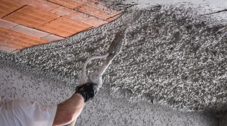 Arbeitskraft trägt Zementputz auf einer Arbeitsfläche an der Decke auf.