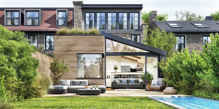 Moderner Garten mit Pool und einer gemütlichen Terrasse aus Holz. Darauf stehen ein paar Gartenmöbel in anthrazit.