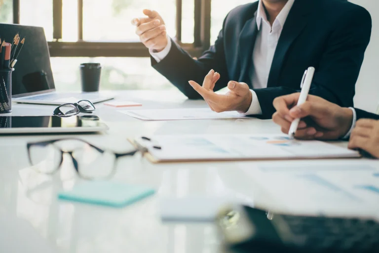Zwei Männer sitzen an einem Schreibtisch und arbeiten an einem Firmenkonzept.