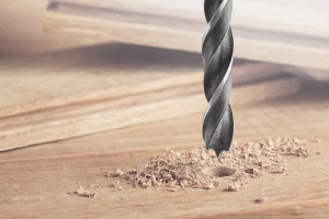Ein Holzbohrer der in ein Holzbrett bohrt.