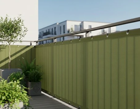 Eine olivgrüne Balkonverkleidung an einem Balkongeländer aus Metall.