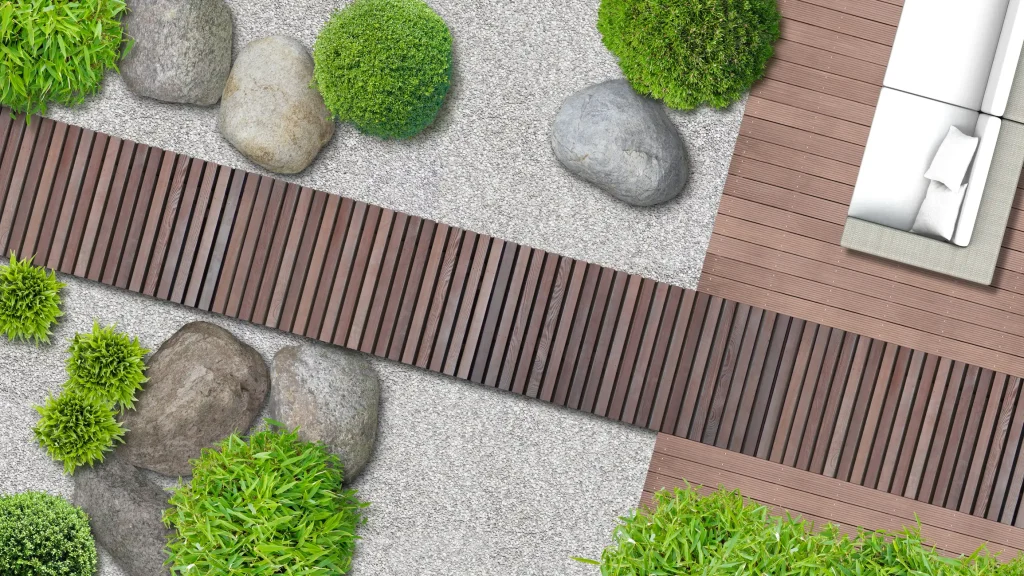 Draufsicht auf ein modernes Gartenkonzept mit einem geradlinigen Gartenweg aus dunklen Holzlatten, der über eine helle Kiesfläche führt. Ergänzt durch Findlinge, Buchsbaumkugeln und eine angrenzende Holzterrasse.