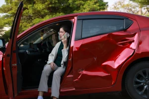 Eine Frau sitzt in einem Unfallwagen und hält ihr Handy ans Ohr.