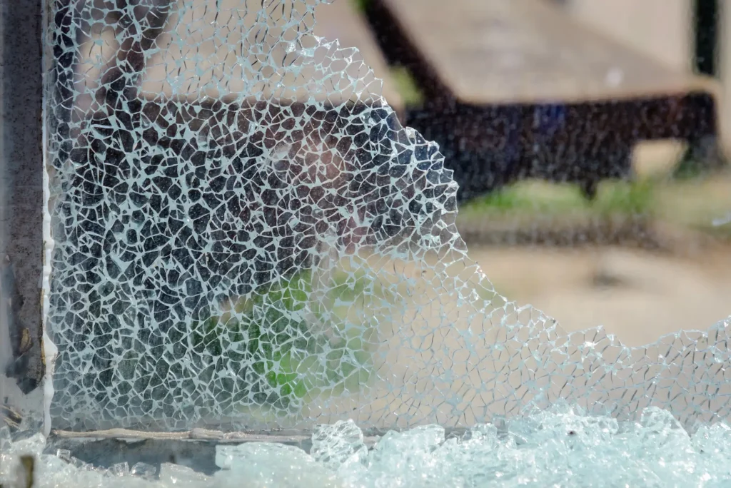 Nahaufnahme einer zerbrochenen Scheibe aus Einscheibensicherheitsglas (ESG), die das charakteristische engmaschige Netz aus stumpfkantigen Glaskrümeln ohne scharfe Splitter zeigt.