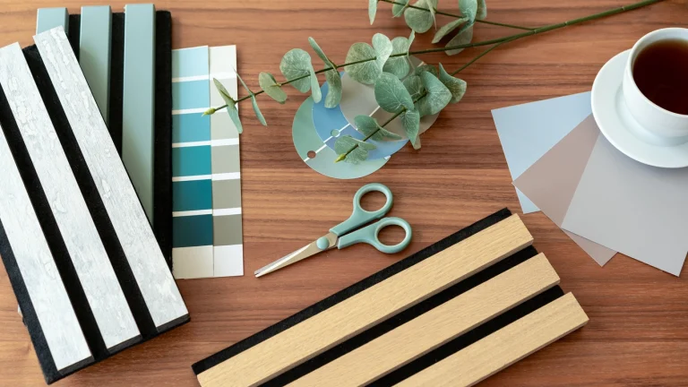 Musterteile von Akustikpaneelen in verschiedenen Farben auf einem Tisch.