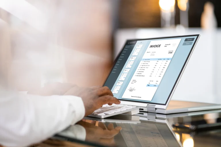 Eine Person bearbeitet eine Rechnung an einem Laptop.