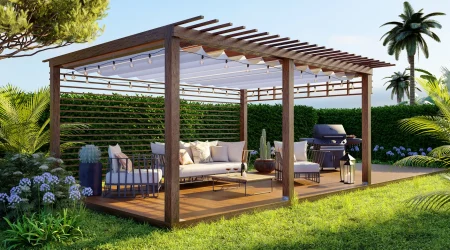 Moderne Garten-Terrasse mit einer dunklen Holz-Pergola, die mit einer weißen Markise und einer Lichterkette ausgestattet ist. Darunter befindet sich eine gemütliche Lounge-Ecke mit hellen Polstermöbeln und ein Grillplatz im Hintergrund.
