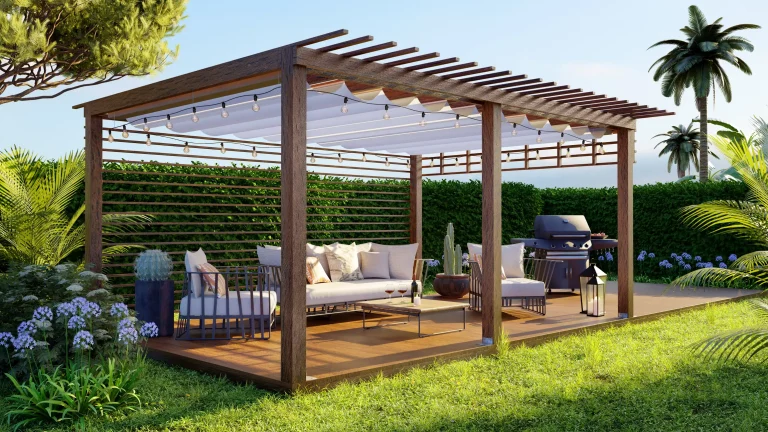 Moderne Garten-Terrasse mit einer dunklen Holz-Pergola, die mit einer weißen Markise und einer Lichterkette ausgestattet ist. Darunter befindet sich eine gemütliche Lounge-Ecke mit hellen Polstermöbeln und ein Grillplatz im Hintergrund.