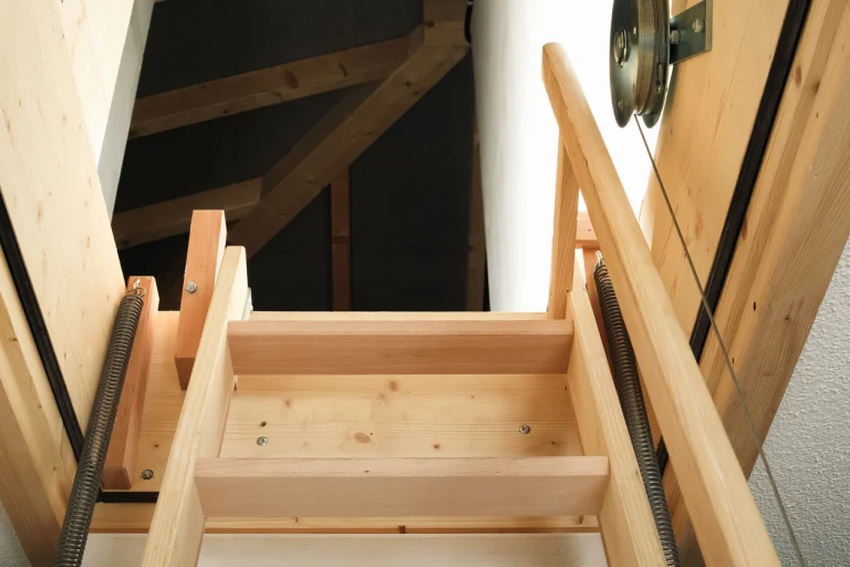 Blick von unten auf eine geöffnete Dachbodentreppe aus Holz mit Dichtung.