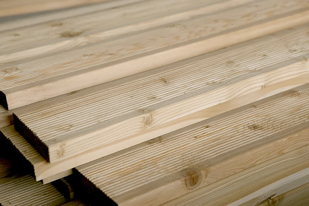 Nahaufnahme von geriffelten Holzterrassendielen aus Kiefernholz. Die profilierte Oberfläche der braunen Dielen zeigt eine feine Riffelung zur Erhöhung der Rutschfestigkeit im Außenbereich.