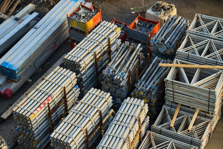 Metallstangen, Rahmen und Baumaschinen auf einer Baustelle.