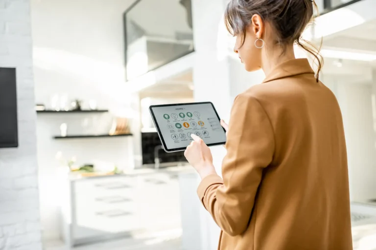 Eine Frau bedient in einer modernen Wohnung eine Smart-Home-App zur KNX-Gebäudeautomation auf einem Tablet, um Licht und Haustechnik zu steuern.