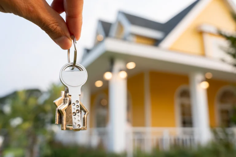 Ein Immobilienmakler hält den Schlüssel zu einem Haus in der Hand.