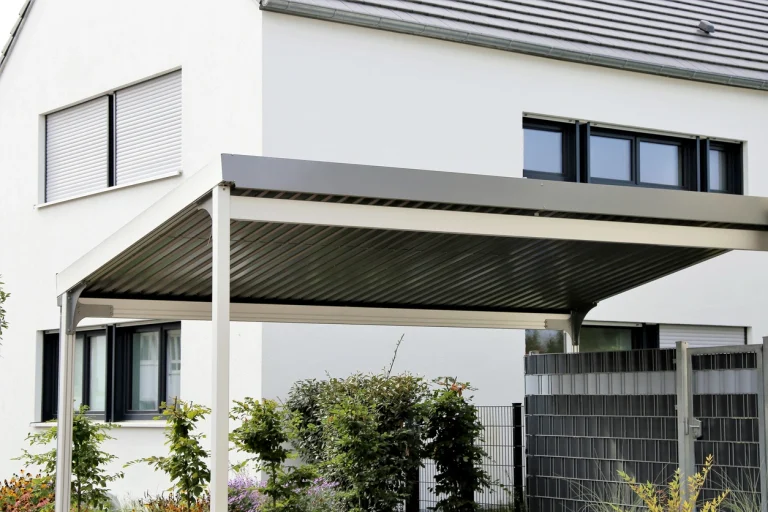 Ein Carport neben einem Einfamilienhaus in einer deutschen Wohnsiedlung.