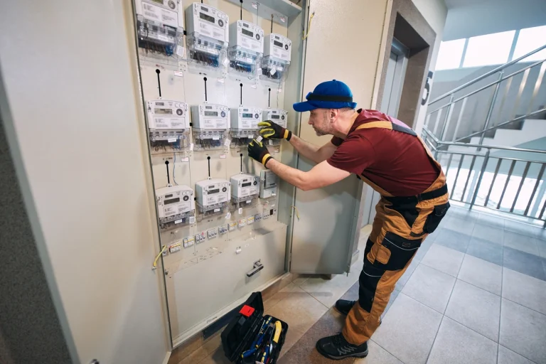 Elektriker installiert neuen FI-Schalter in Hauselektronik.