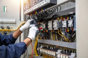Elektriker-Notdienst prüft Kontakte im Schaltschrank mit Messspitzen zur Reparatur.