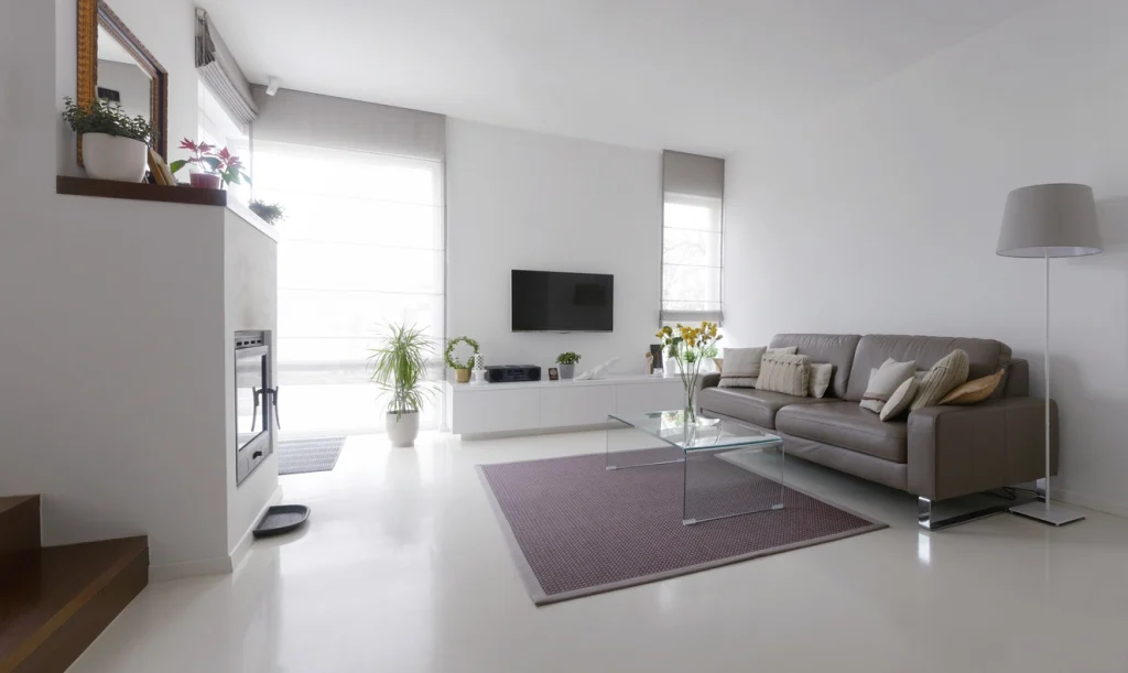 Modernes Wohnzimmer mit fugenlosem, glänzendem Epoxidharzboden in heller Optik.