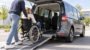 Rollstuhlgerechtes Auto mit Heckrampe beim Einfahren eines Rollstuhls in den abgesenkten Fahrzeugbereich.