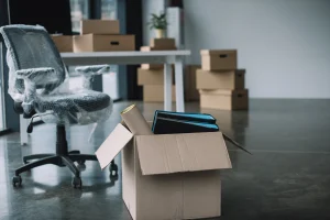 Ein Büro voller Umzugskartons und verhüllten Büromöbeln, fertig gepackt für einen Umzug.