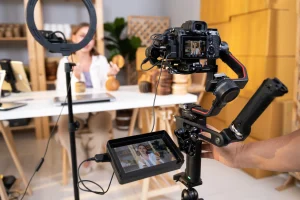 Eine Influencerin sitzt vor ihrer Kamera und nimmt eine Videosequenz auf.