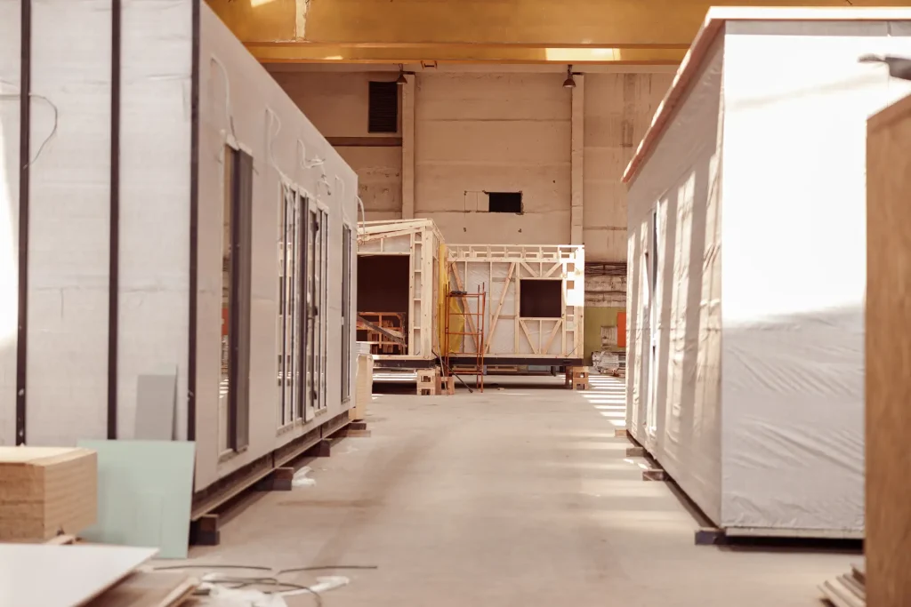 Produktionshalle für modulare Gebäude in Leichtbauweise – vorgefertigte Raummodule mit Holzrahmenkonstruktion beim modernen Hausbau.