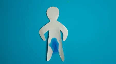 Figur aus Papier mit nassem Schritt als Konzept der Urininkontinenz