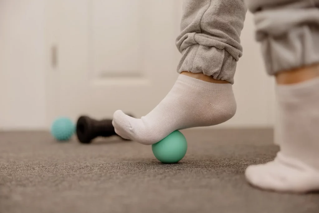 Übung zur Fußgymnastik mit Socken auf einem kleinen grünen Gymnastikball