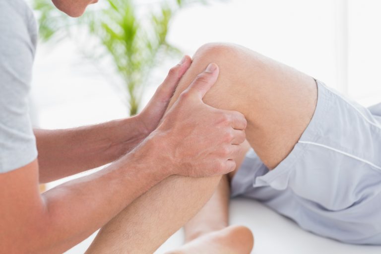 Mann bekommt eine Kniemassage von seinem Physiotherapeuten